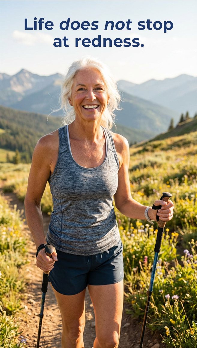 Active woman hiking outdoors, smiling, 'Life does not stop at redness' headline
